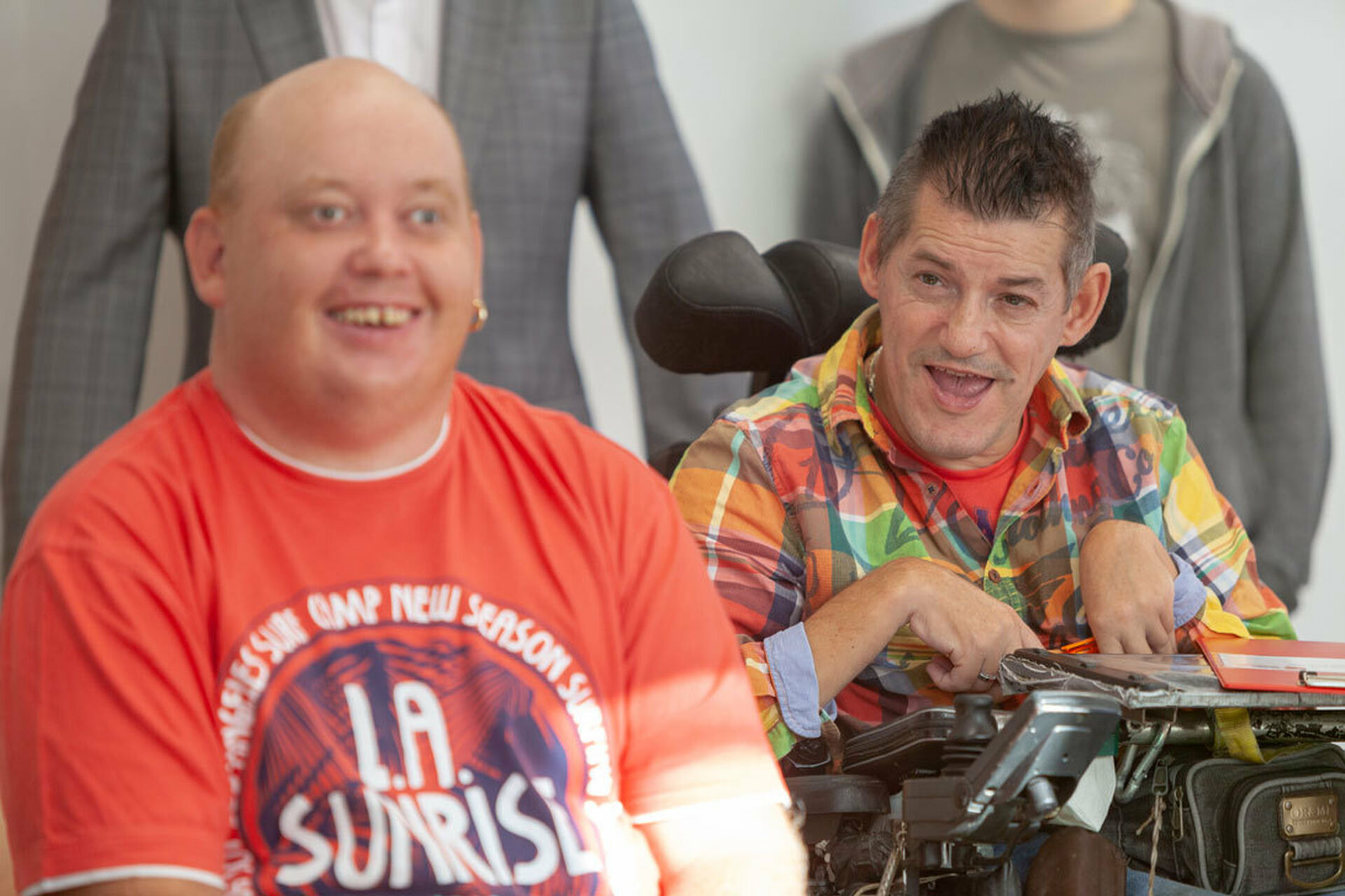 Zwei Menschen mit Behinderung sitzen nebeneinander mit Blick zur Kamera (Bild: FSW)