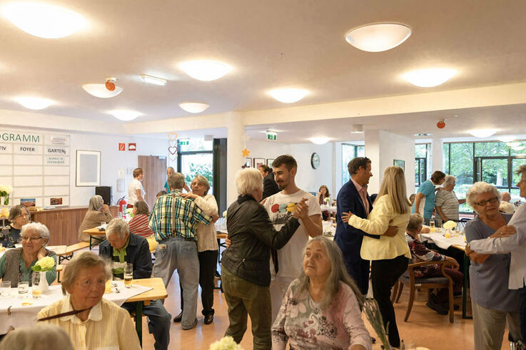 BesucherInnen des Tageszentrum Winarskystraße feiern 10-jähriges Bestehen und tanzen dabei in einem größeren Saal (Bild: FSW)